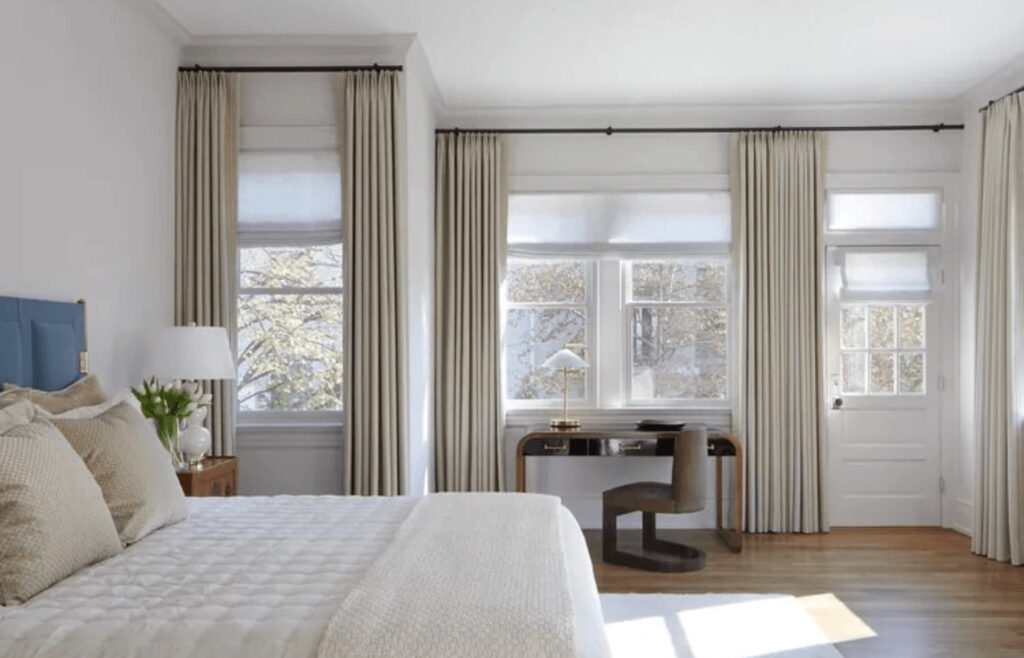 Stores romains et rideaux opaques dans une chambre pour bloquer la lumière