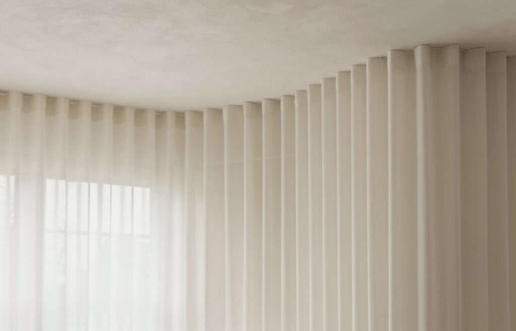 Détail de rideaux ripplefold sur mesure avec plis réguliers et tissu léger