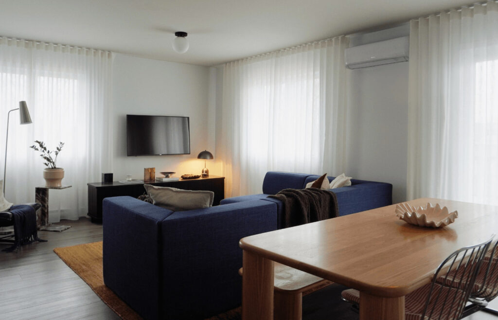 Voilage sur mesure installé dans un salon lumineux avec grandes fenêtres