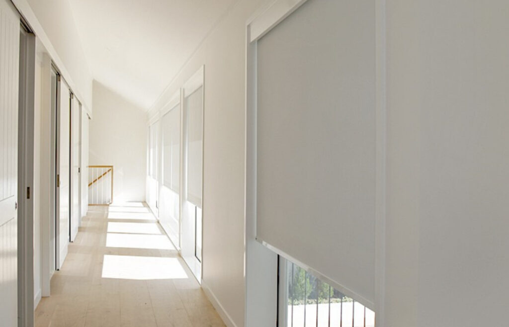 Store à rouleau motorisé installé dans un couloir moderne avec contrôle automatique de la lumière