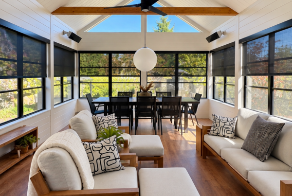 Solarium lumineux avec toiles solaires noires sur mesure et fascias noirs installés sur les fenêtres.